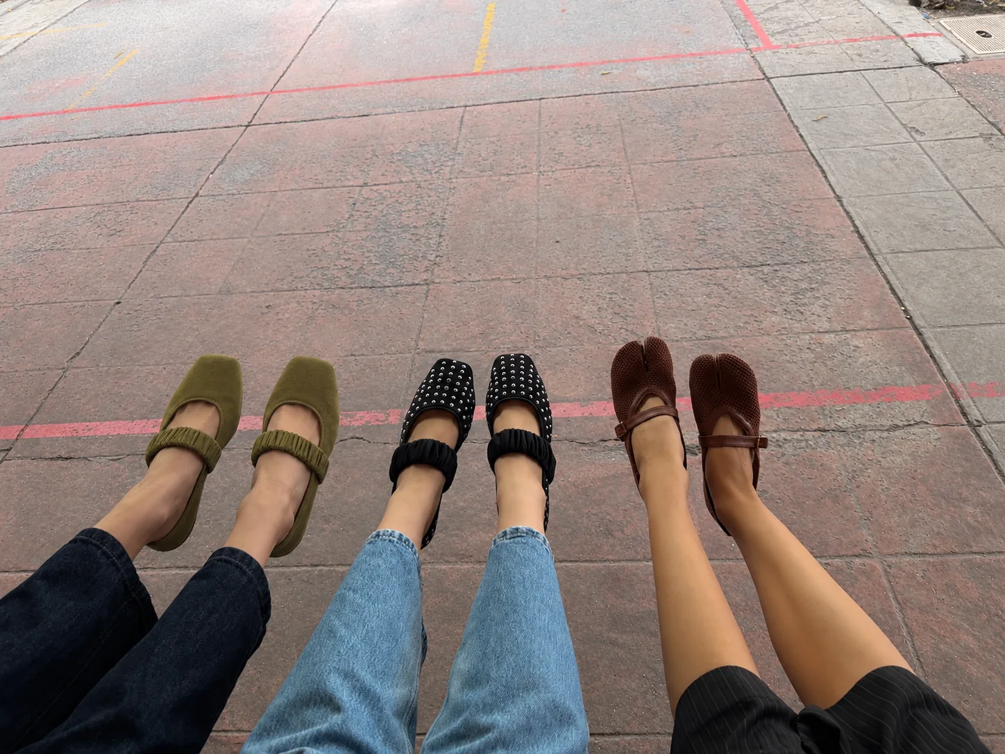 Tres amigas sentadas en la banqueta con flats Nolié puestos